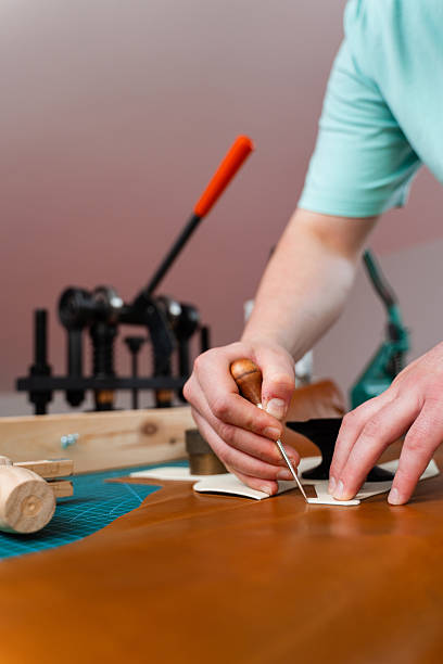 istock Leather Cutting with Pattern. Leather artisan uses templates to cut hides accurately. Leather crafting process showing precise cutting. Skilled artisan cuts leather with accuracy. 2238597611