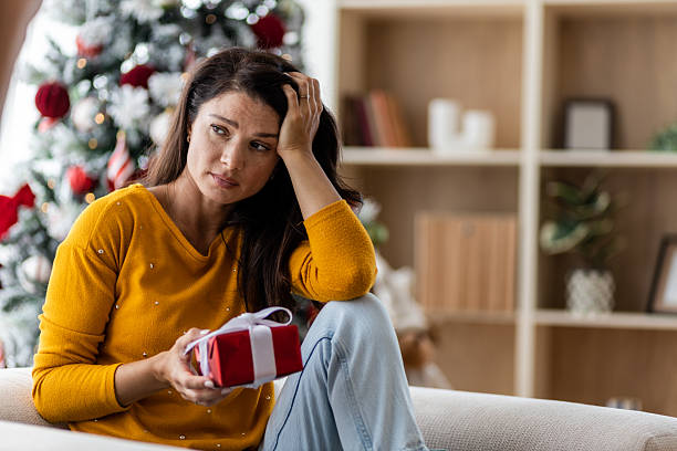 istock Thoughtful woman holding a wrapped present 2238597804