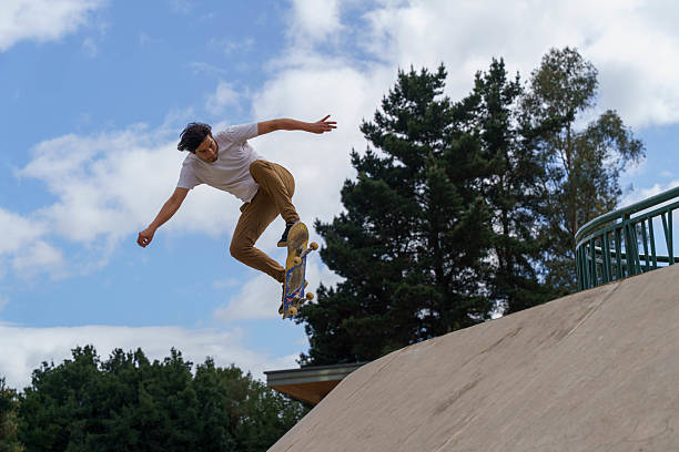 istock Young man skateboarding while doing jump trick in skatepark 2238600084