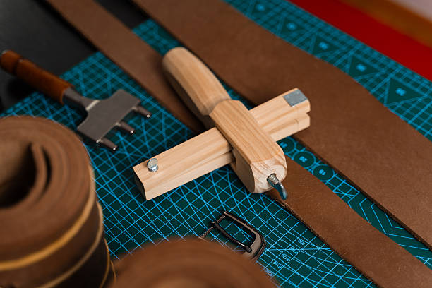 istock Leatherworking setup featuring tools, buckle, and leather strips laid out neatly on a mat, ready for belt making. Leathercraft tools and belt-making preparation. 2238600098