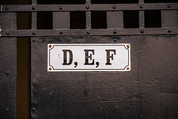 Metal gate with sign labeled D E F.