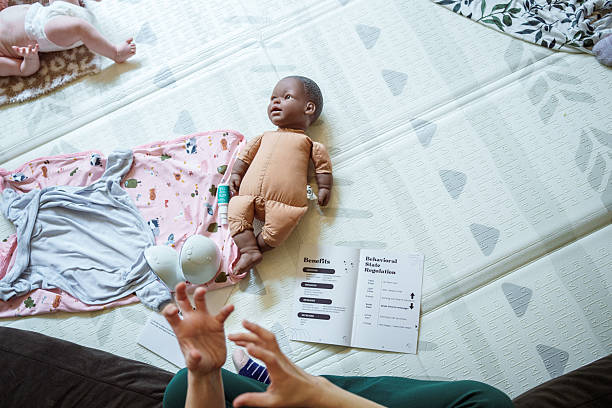istock Doll and class brochure resting on floor at infant massage class 2238609825