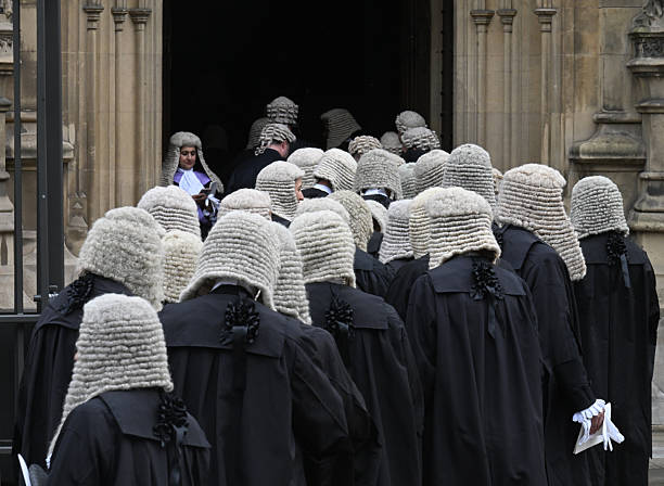 UK judges in traditional ceremonial dress with full bottomed wigs in procession at Westminster in London, UK on the first day of the new legal year. The black robes denote that they are appeal court judges