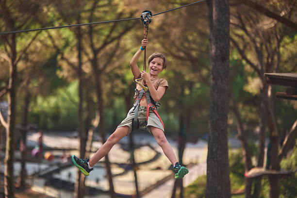 istock Boy having fun ziplining at adventure park 2238614333