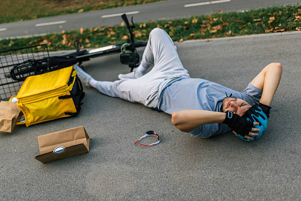 istock Fallen delivery courier with scattered packages on street 2238616119