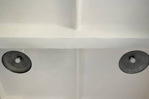 Industrial style ceiling with exposed white beams and two pendant lamps