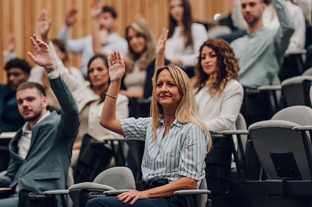istock Conference audience participating, raising hands for questions 2238623686
