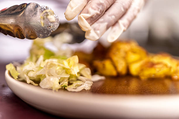 istock Chef plating fresh lettuce with fried food 2238627443