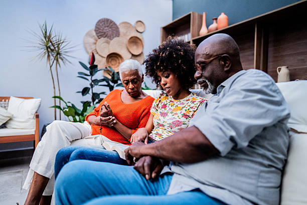 Family praying reading bible at home