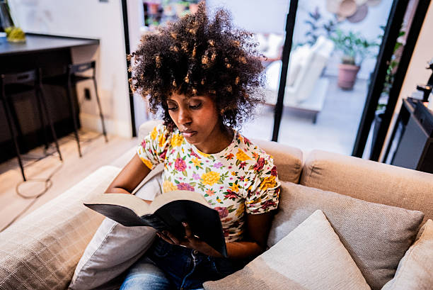 istock Young woman reading bible at home 2238630508