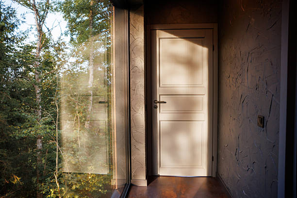 Close-up of open door and door handle with a key and a keychain shaped house