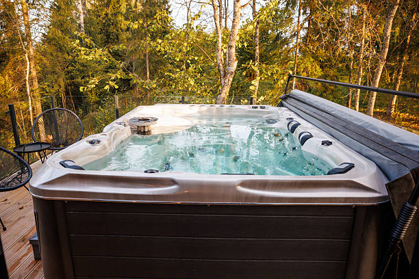 istock Modern Hot Tub on Wooden Deck Surrounded by Tall Green Trees 2238634610