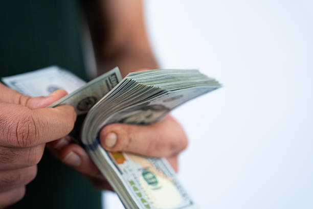 istock Man counting dollar bills in hands 2238634959