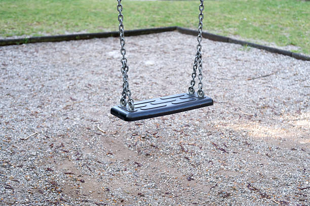 istock Empty swing in quiet park, no children playing, low birth rate, social concern, deserted playground, Abandoned swing set, calm atmosphere, lonely scene, social concern, nature around 2238641362