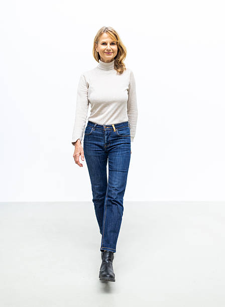 istock Smiling mature woman walking on studio background 2238643369
