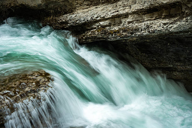 istock Water Cascades Over Rock Ledge in Nature's Embrace 2238643465