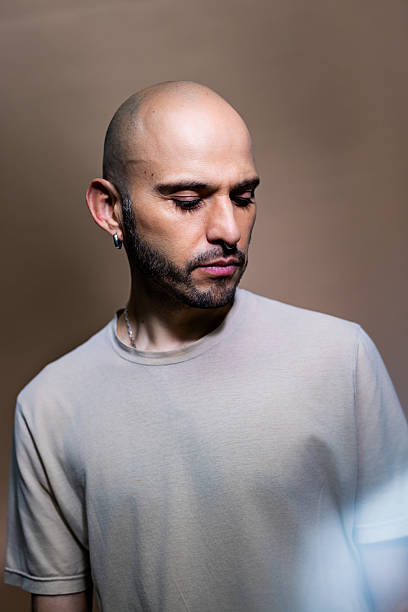 istock Mid adult man with beard thinking against brown background 2238643873