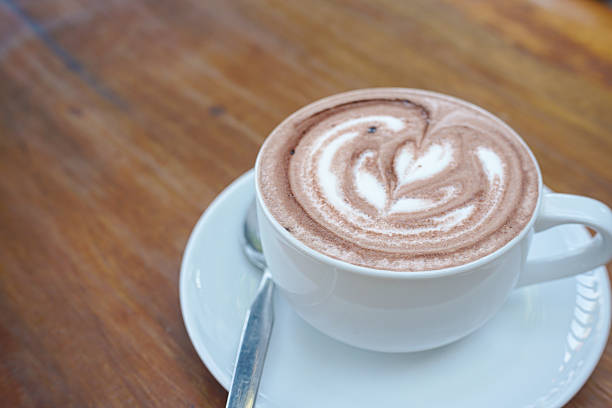 A cup of coffee with latte art on a wooden table