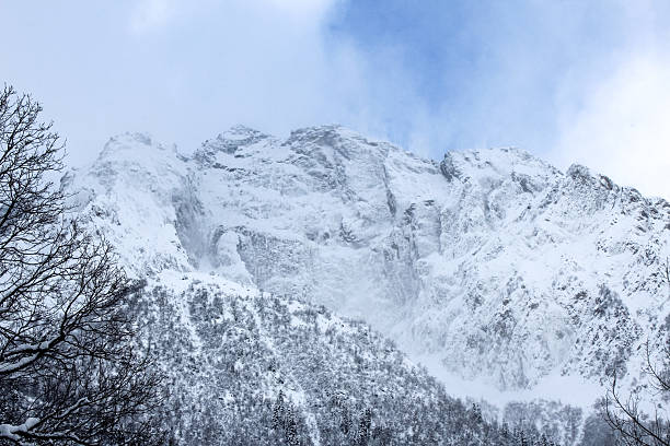 Snow-covered mountain peaks against a blue winter sky