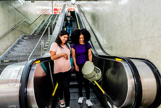 istock Friends talking on the escalator 2238650627
