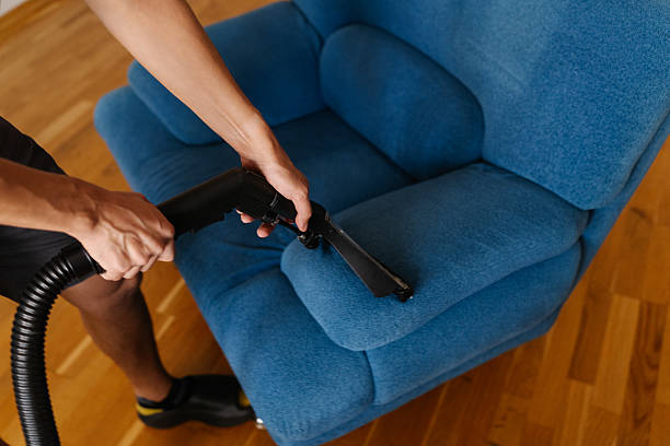 istock Top view of cleaning service worker washing blue upholstered sofa with vacuum cleaner, providing professional cleaning and maintenance for home furniture. 2238653349