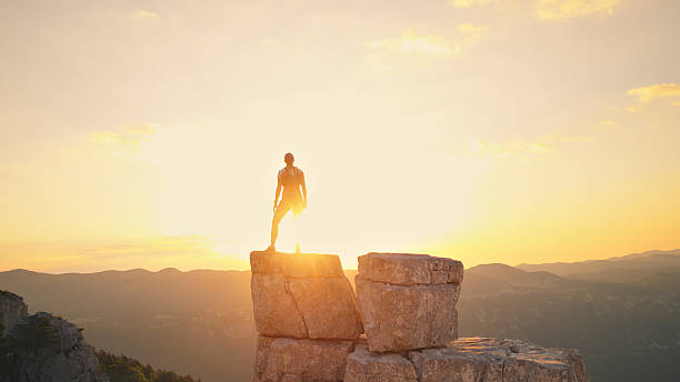 istock Runner Silhouetted on Rocky Peak at Sunrise 2238653401