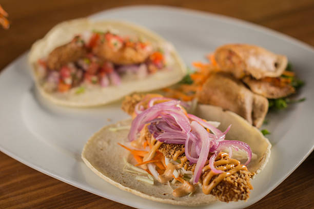 istock Assortment of Mexican Fish Tacos and a Fried Empanada on a White Plate 2238653796