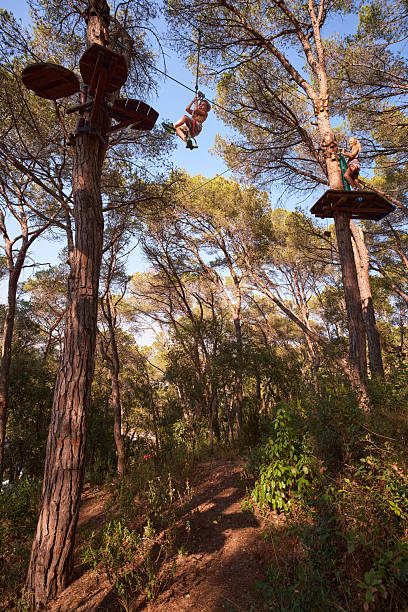 istock Mother and child zip-lining through forest adventure park 2238654747