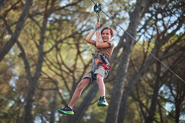 istock Boy ziplining through forest with big smile 2238655736