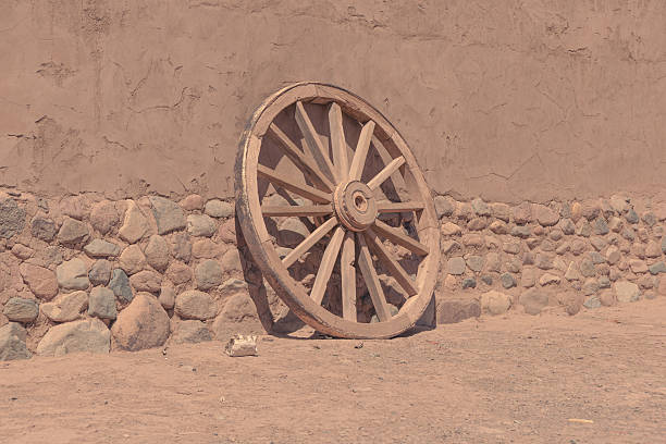 Taos, NM Style: Old Wood Wagon Wheel Against Wood Shinges.