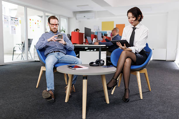 Happy and relaxed man with down syndrome and teacher talking during IT computing class
