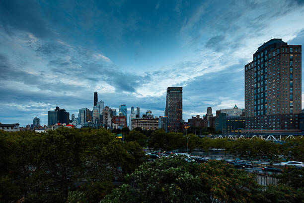 View across autumnal trees in Trinity Park towards the Downtown Brooklyn skyline on an overcast evening in New York City. This still image is part of a series taken at different times of day from the same location; a time lapse video is also available.