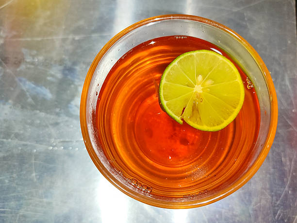 Ice cube is floating on brown iced tea with morning sunlight