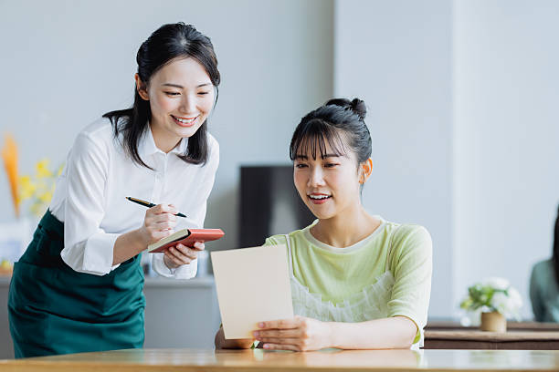 istock Young woman ordering from a waiter at a cafe 2238667538