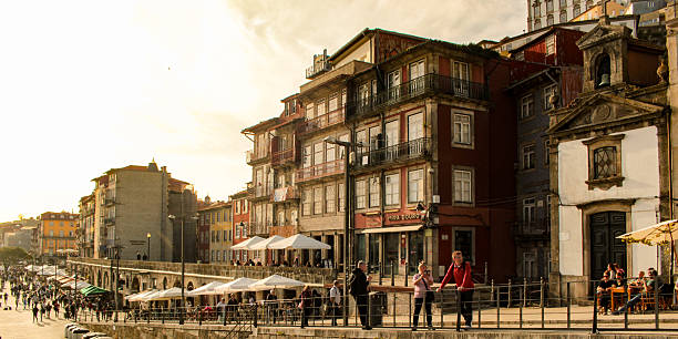 Several people and medieval buildings on the Ribeira quay, in the city of Porto, Portugal.