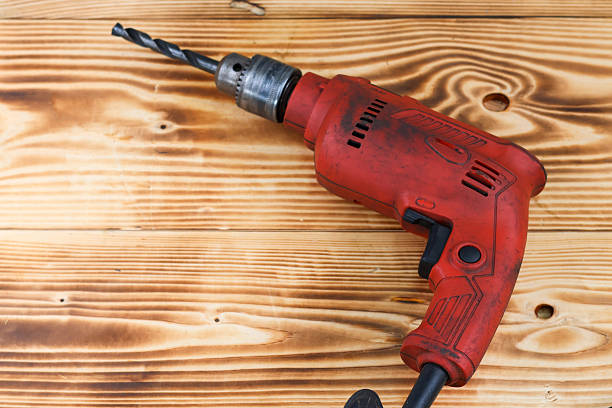 Close up electric drill on wooden table, electric hand tools.