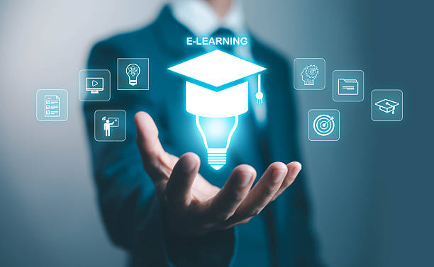 istock Businessman holding virtual e-learning icon with graduation cap and light bulb, symbolizing online education, digital training, remote study, knowledge innovation, and professional skill development. 2238671803
