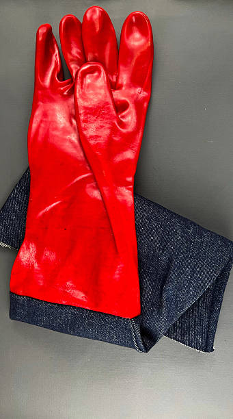 istock Shiny red rubber gloves connected with denim fabric 2238671877