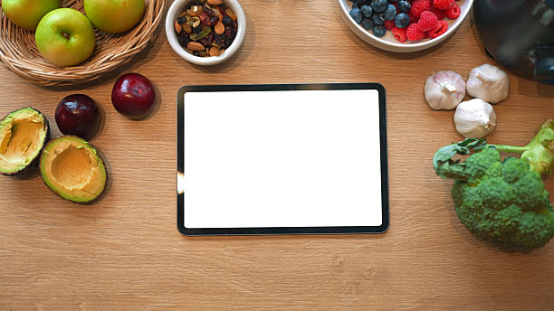 istock Digital tablet with blank screen surrounded by organic food ingredients, for diet planning or nutrition app display 2238672692