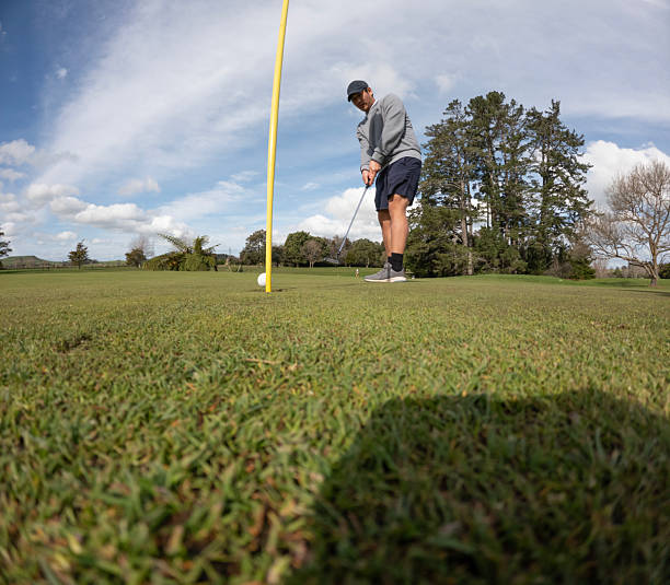 istock Low angle view of a man putting on a golf course 2238673403