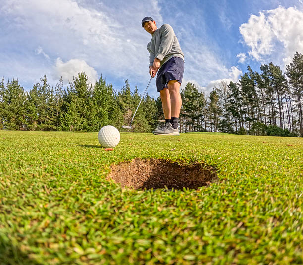 istock Low angle view of a man putting on a golf course 2238673418