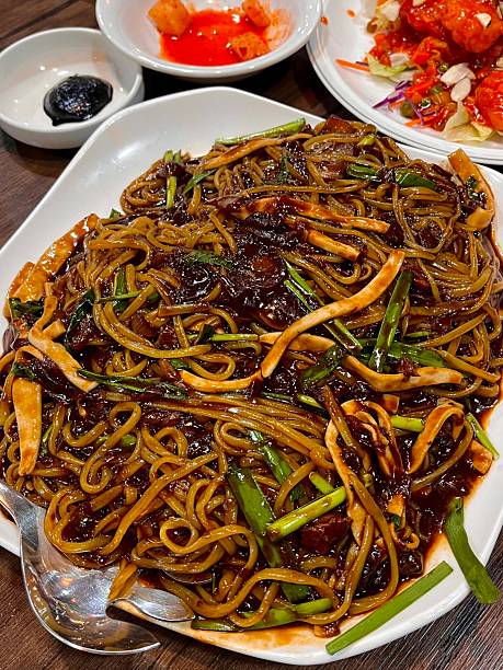 Classic jajangmyeon with thick noodles in a rich black bean sauce, garnished with sliced cucumber and sesame seeds. A beloved Korean-Chinese comfort dish, full of savory depth and flavor.