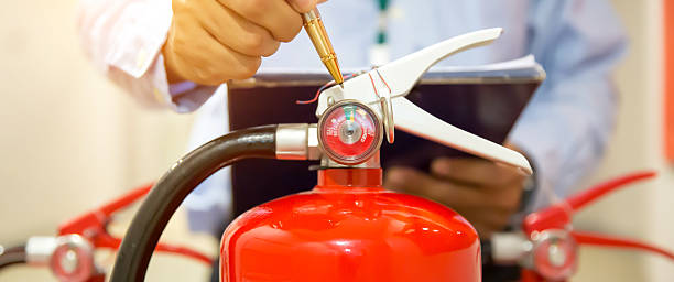 istock Fire extinguisher has hand engineer inspection checking pressure gauges to prepare fire equipment for protection and prevent emergency and safety rescue and alarm system training concept. 2238681646