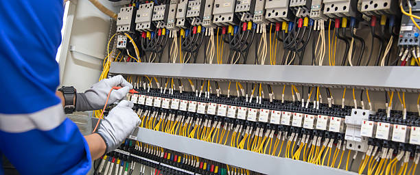 istock Electricity and electrical maintenance service, Engineer hand holding AC voltmeter checking electric current voltage at circuit breaker terminal and cable wiring main power distribution board. 2238681756