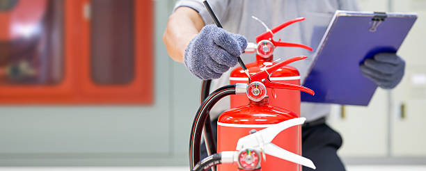 istock Fire extinguisher has hand engineer inspection checking pressure gauges to prepare fire equipment for protection and prevent emergency and safety rescue and alarm system training concept. 2238682449