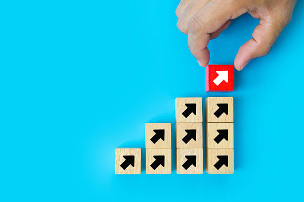 istock Close-up hand chooses cube wooden toy block stack with arrow icon pointing to opposite directions for way of business change or administrative leader planning company and transform concept. 2238682815