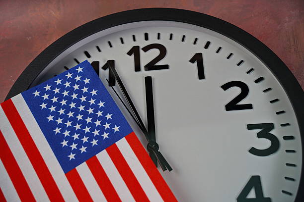 istock The US flag on the clock face on a paper background. 2238685069