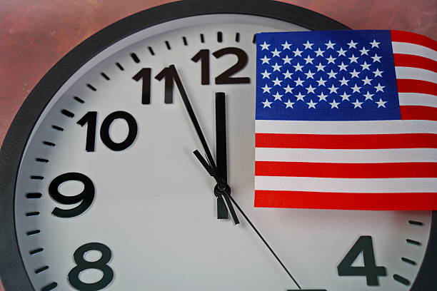 istock The US flag on the clock face on a paper background. 2238685073