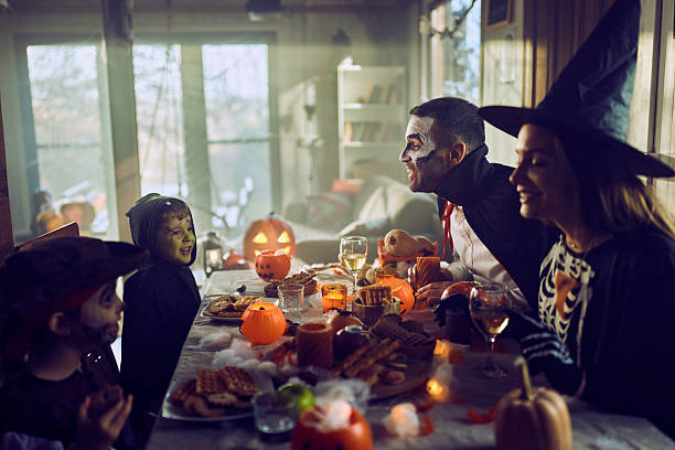 istock Happy family talking on Halloween at dining table. 2238685268