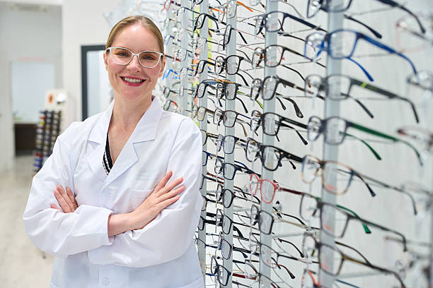 istock Optician smiling in front of eyeglasses display in optical store 2238685933